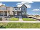 A modern home with gray and white siding, a manicured lawn, and a paved walkway at 21022 E 63 Dr, Aurora, CO 80019
