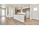 Open kitchen view with center island, stainless appliances, and a seamless flow into adjacent living spaces at 21022 E 63 Dr, Aurora, CO 80019