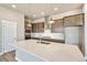 Close-up of a kitchen island with a quartz countertop, stainless steel sink, and modern pendant lighting at 21022 E 63 Dr, Aurora, CO 80019