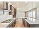 Kitchen with stainless steel gas range and vent hood, tile backsplash, plus quartz countertops on the center island at 21022 E 63 Dr, Aurora, CO 80019