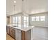 Open-concept kitchen and living area, highlighted by a large island and abundant natural light from expansive windows at 21022 E 63 Dr, Aurora, CO 80019