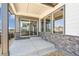 Covered outdoor patio featuring stone accents, a concrete floor, and sliding glass doors at 21022 E 63 Dr, Aurora, CO 80019