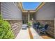 Inviting front porch with a stone pillar, offering a cozy outdoor seating area at 20553 E 50Th Pl, Denver, CO 80249