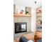 A fireplace with books on shelves creating a relaxed cozy living space at 16012 E Floyd Ave, Aurora, CO 80013