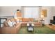 A comfortable living room with a large brown sectional sofa and a green patterned rug at 16012 E Floyd Ave, Aurora, CO 80013