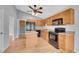 Well-equipped kitchen featuring an island, sleek black appliances, granite countertops, and wood cabinets at 4825 S Ammons St # 133, Littleton, CO 80123