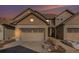 Tan two-story townhome with a two-car garage and landscaping at 12125 W Ida Dr, Littleton, CO 80127