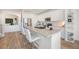 White kitchen with an island, stainless steel appliances and hardwood floors at 12125 W Ida Dr, Littleton, CO 80127