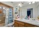 Bathroom with double sinks, and a tiled shower with glass door at 18619 E 50Th Pl, Denver, CO 80249