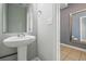 Downstairs half-bathroom featuring pedestal sink and mirror at 18619 E 50Th Pl, Denver, CO 80249
