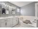 Bright bathroom features a double vanity with marble countertop and a soaking tub at 7648 S Sicily Way, Aurora, CO 80016