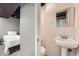 Neutral basement bathroom with a small pedestal sink and open access to the finished bedroom at 7648 S Sicily Way, Aurora, CO 80016