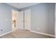 Bedroom with gray walls, two closets, and access to the hallway with stairs at 7648 S Sicily Way, Aurora, CO 80016