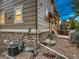 Home exterior with stone accents, tan siding, rock landscaping, and air conditioning unit at 7648 S Sicily Way, Aurora, CO 80016