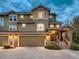 Attractive townhome with stone accents, two-car garage, and inviting front entrance with warm lighting at 7648 S Sicily Way, Aurora, CO 80016
