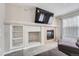 Close-up of a modern fireplace and built-in shelving in the living room with TV at 7648 S Sicily Way, Aurora, CO 80016