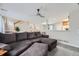 Spacious living room area featuring a comfortable sofa, ceiling fan, and open access to other areas at 7648 S Sicily Way, Aurora, CO 80016