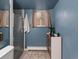 Cozy bathroom with a tiled shower, blue walls, and a stylish vanity with modern accents at 11165 W 58Th Ave, Arvada, CO 80002