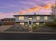 Charming two-story home featuring a well-maintained lawn and a spacious two-car garage at sunset at 11165 W 58Th Ave, Arvada, CO 80002