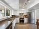 Bright kitchen featuring white cabinetry, stainless steel appliances, and tile floors at 11165 W 58Th Ave, Arvada, CO 80002