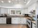 Bright kitchen featuring white cabinetry, stainless steel appliances, and tile floors at 11165 W 58Th Ave, Arvada, CO 80002