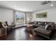 Bright living room with dark wood floors, a leather couch, decor, and an open window at 11165 W 58Th Ave, Arvada, CO 80002