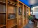 Stylish office features floor to ceiling wooden bookshelves with plants, books, and decorations at 11165 W 58Th Ave, Arvada, CO 80002