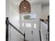 Staircase with white door, decor, hanging wicker light, and black railings at 11165 W 58Th Ave, Arvada, CO 80002