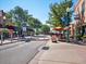 Charming street view with local shops, sidewalk dining, and mature trees offering a welcoming ambiance at 11165 W 58Th Ave, Arvada, CO 80002