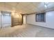Finished basement area with carpet, built-in shelving and egress window at 7721 S Curtice Way # B, Littleton, CO 80120