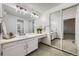 Bathroom features white vanity and cabinets, large mirror, vanity lights and mirrored closet doors at 7721 S Curtice Way # B, Littleton, CO 80120