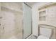 Bathroom features marble shower and tiled floors with white toilet and cabinet at 7721 S Curtice Way # B, Littleton, CO 80120