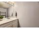 Bright bathroom featuring a single sink vanity, a large mirror, and neutral walls at 7721 S Curtice Way # B, Littleton, CO 80120