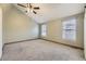 Spacious bedroom features a ceiling fan, neutral walls and carpeting, and large windows at 7721 S Curtice Way # B, Littleton, CO 80120