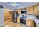 Spacious kitchen featuring stainless steel appliances and wood cabinets with light countertops and hardwood floors at 7721 S Curtice Way # B, Littleton, CO 80120