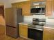 This kitchen features stainless steel appliances and wooden cabinets at 7721 S Curtice Way # B, Littleton, CO 80120