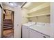 Convenient laundry room area with washer, dryer, storage shelves and stairs at 7721 S Curtice Way # B, Littleton, CO 80120