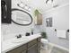 Bathroom with silver framed mirror, gray cabinets, white countertop, toilet, tub, and patterned rug at 190 E Highline Cir # 302, Centennial, CO 80122