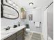 Bathroom with silver framed mirror, gray cabinets, white countertop, toilet, tub, and patterned rug at 190 E Highline Cir # 302, Centennial, CO 80122