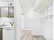 Hallway with a white kitchen, cabinets, tile floors, and shelving and rods in closet at 190 E Highline Cir # 302, Centennial, CO 80122