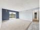 Spacious living room with neutral carpet, blue accent wall, and sliding glass doors to the balcony at 190 E Highline Cir # 302, Centennial, CO 80122
