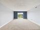 Bright, empty living room featuring plush carpet, a blue accent wall, and sliding glass doors at 190 E Highline Cir # 302, Centennial, CO 80122