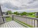 Spacious grey painted deck with views of green lawns and other townhomes under a cloudy sky at 190 E Highline Cir # 302, Centennial, CO 80122
