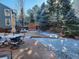 A cozy snowy patio with outdoor table and chairs surrounded by lovely trees at 8850 W Cannes Dr, Littleton, CO 80127