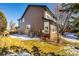 View of the brown siding, air conditioner, and grass-covered lawn in the backyard at 8850 W Cannes Dr, Littleton, CO 80127