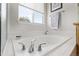 Bathroom has a large soaking tub with chrome fixtures and a window providing lots of natural light at 8850 W Cannes Dr, Littleton, CO 80127