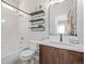 Bathroom has a tub/shower, wood vanity and shelves, and a nice mirror at 8850 W Cannes Dr, Littleton, CO 80127