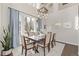 Elegant dining room featuring a large table, modern chandelier, and bright windows at 8850 W Cannes Dr, Littleton, CO 80127