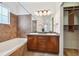 Well-lit bathroom featuring a double sink vanity, tub, and large walk-in closet at 7777 E 23Rd Ave # 203, Denver, CO 80238