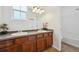 Double vanity bathroom with wood cabinets, ample lighting, and access to a shower/tub at 7777 E 23Rd Ave # 203, Denver, CO 80238